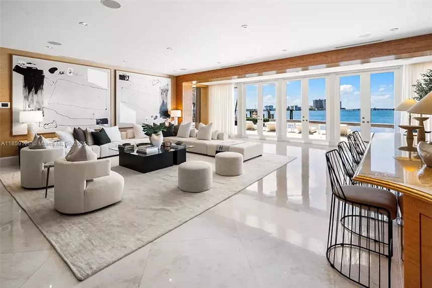 A natural-light-soaked sitting room is pictured with wide views of Biscayne Bay and the Miami metroplex.