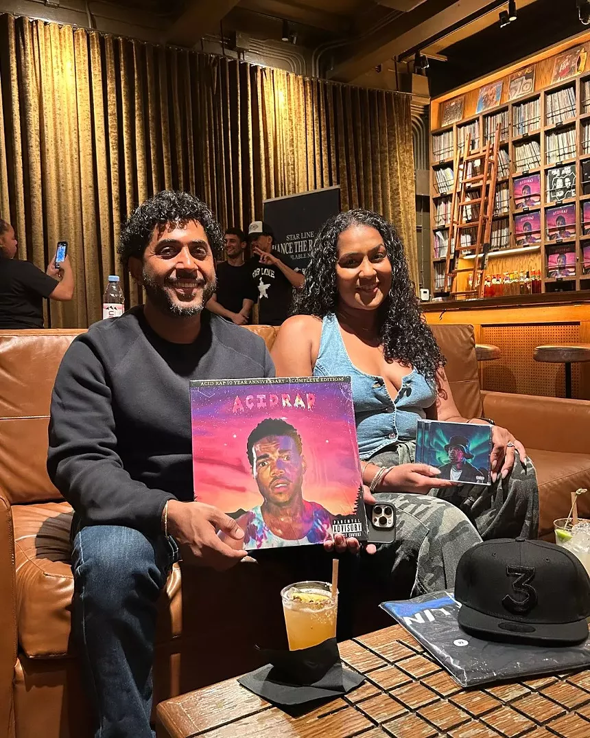 Fans holding Chance the Rapper's merch.