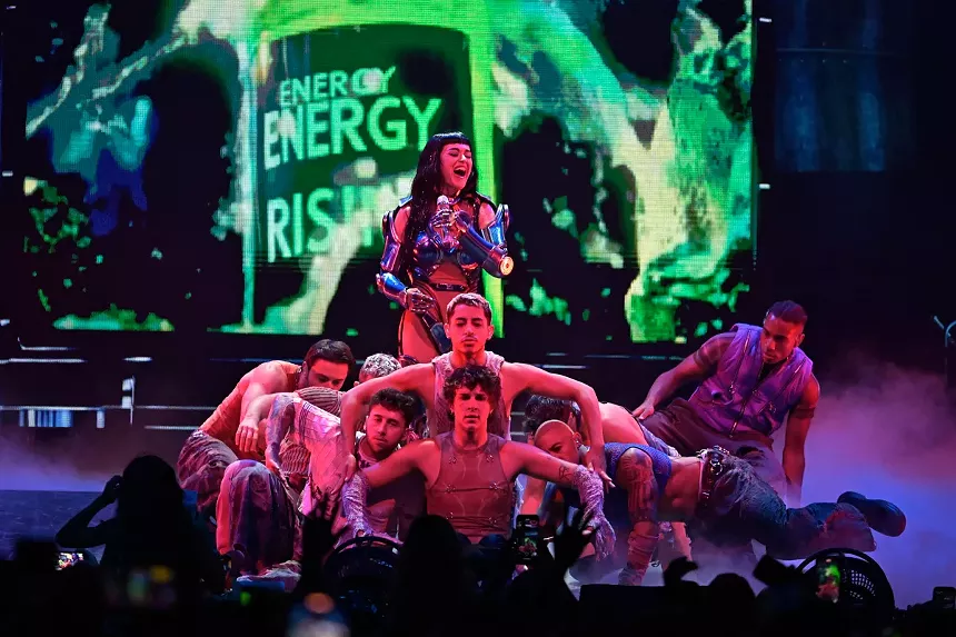 Katy Perry smiling on stage with dancers.