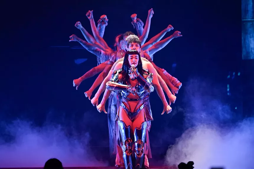 Picture of Katy Perry on stage with dancers and singing.