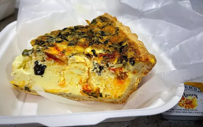 slice of spinach and veggie quiche on a plate
