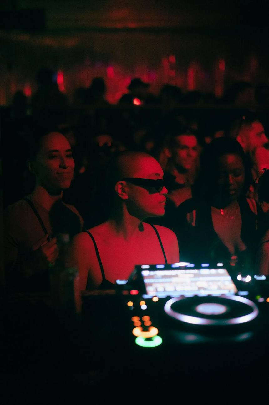 Picture of a techno rave and a woman wearing glasses.