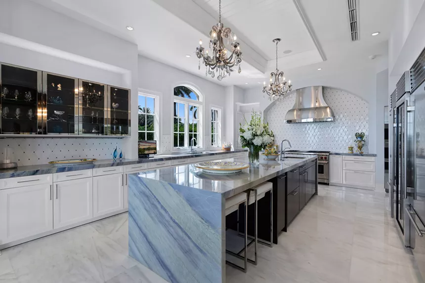 Modern kitchen with custom white cabinets and blue countertops.