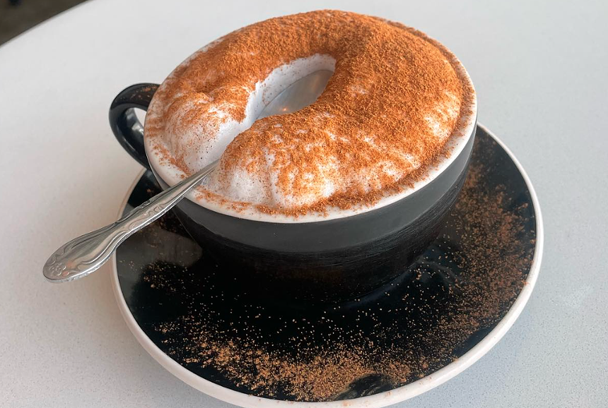 a latte with a spoon plopped on its foam