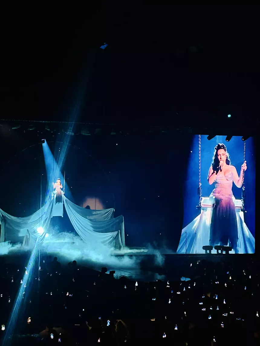 Picture of Kali Uchis sitting on a gigantic swing on stage.