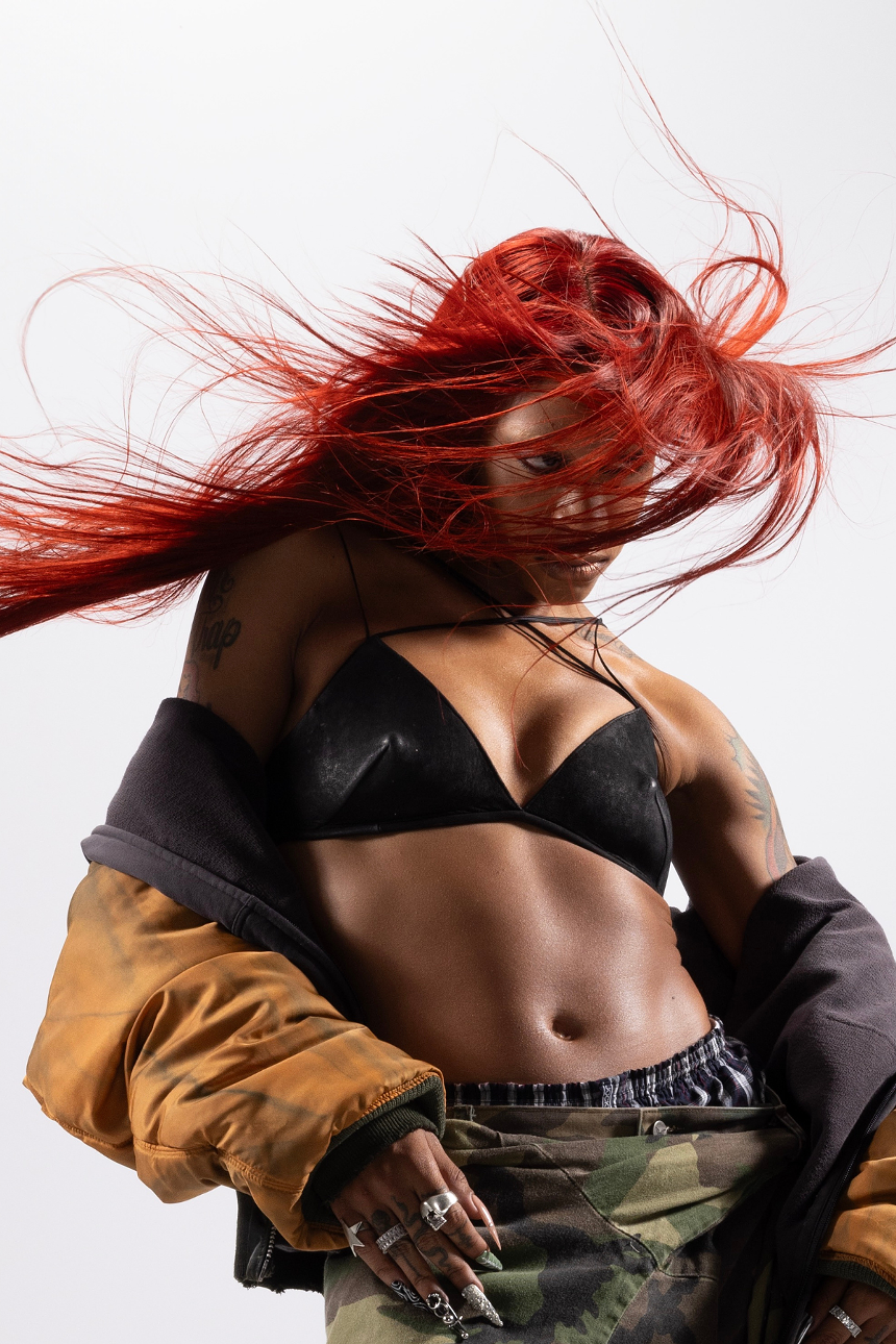 Picture of a fit woman with red hair posing for the camera.