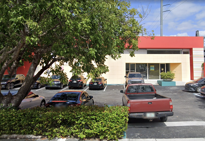 Google Maps screenshot of a boxy yellow and red building with cars parked out front
