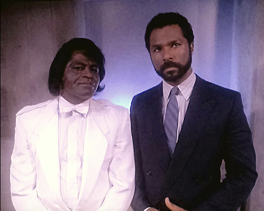 Picture of James Brown and Philip Michael Thomas wearing suits.