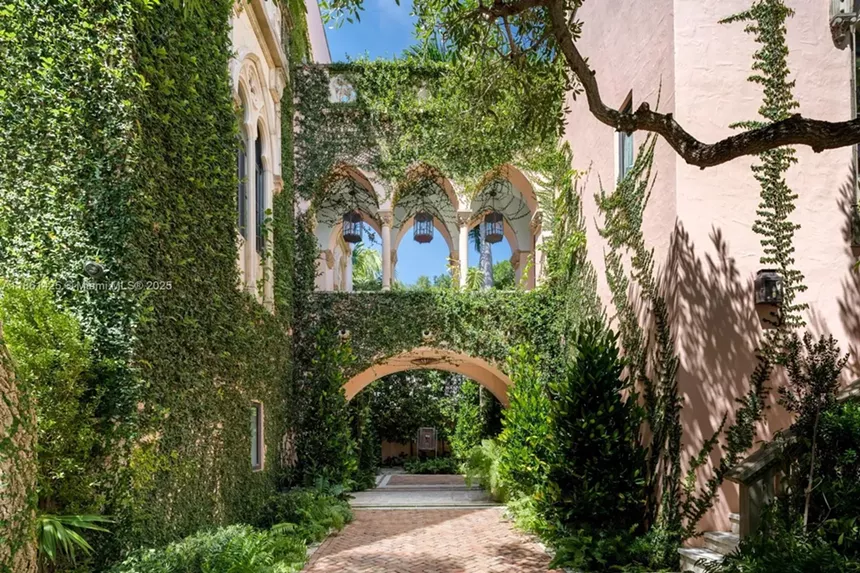 Depicted is the outside of a lush, gothic-inspired mansion.