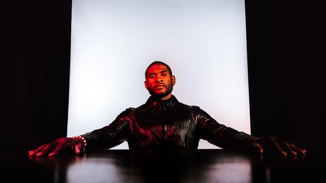 Usher with his arms stretched on a table