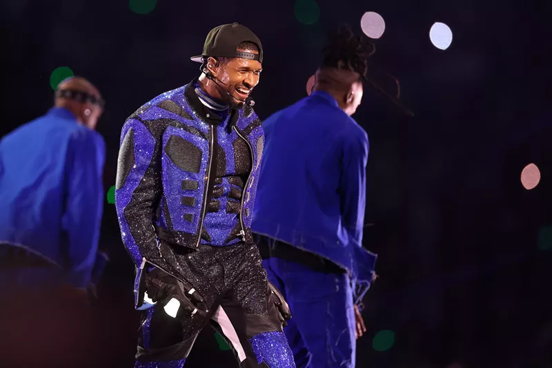 Image: Usher performing onstage in a blue and black sequin outfit