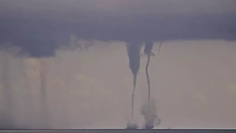 Image: screenshot of twin waterspouts coming together and separating off the Atlantic coast in South Florida