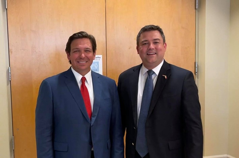 Christian Ziegler (right) stands next to Florida Gov. Ron DeSantis at the Venice Community Center in Venice, Florida on February 10, 2021.
