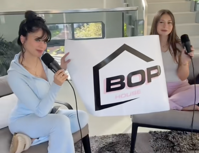 Image: screenshot of a TikTok video showing two models in athleisure holding a banner reading "BOP"
