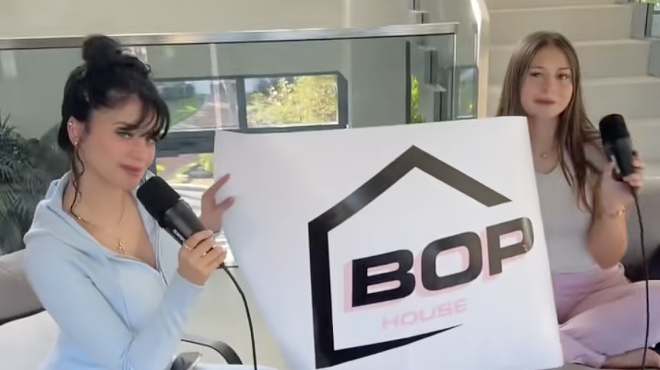 screenshot of a TikTok video showing two models in athleisure holding a banner reading "BOP"