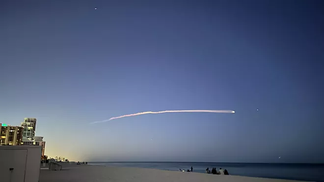 A SpaceX rocket streaking across the night sky, viewed from Miami Beach