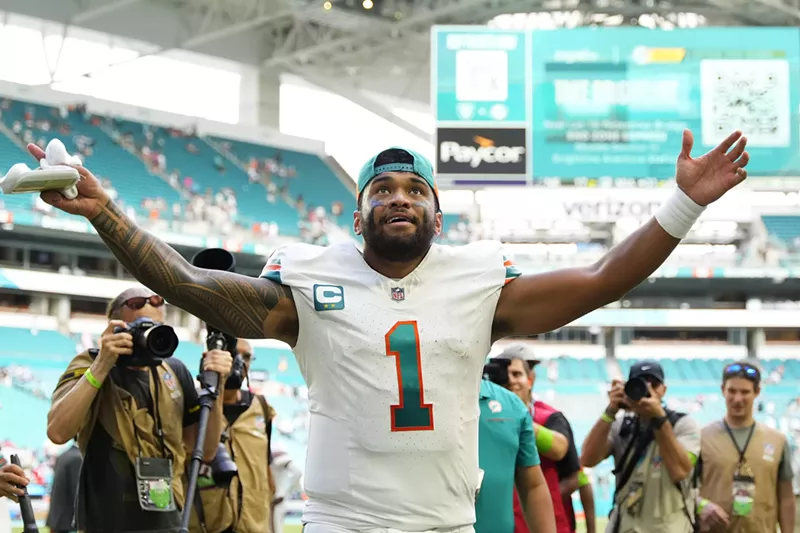 Image: Miami Dolphins quarterback Tua Tagovailoa extends his arms in celebration after a victory