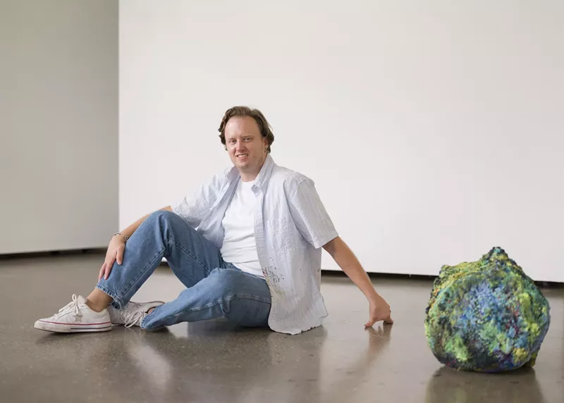 Image: Portrait of artist Addison Wolff next to his artwork
